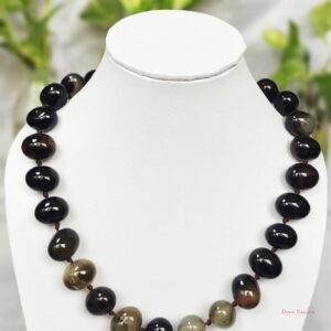 Delightfully dark shades of ovoid-shaped brownish-black coloured Onyx tumbles come together in this knotted 19” single strand necklace, with a strong spring-ring clasp for durability. DN0013
